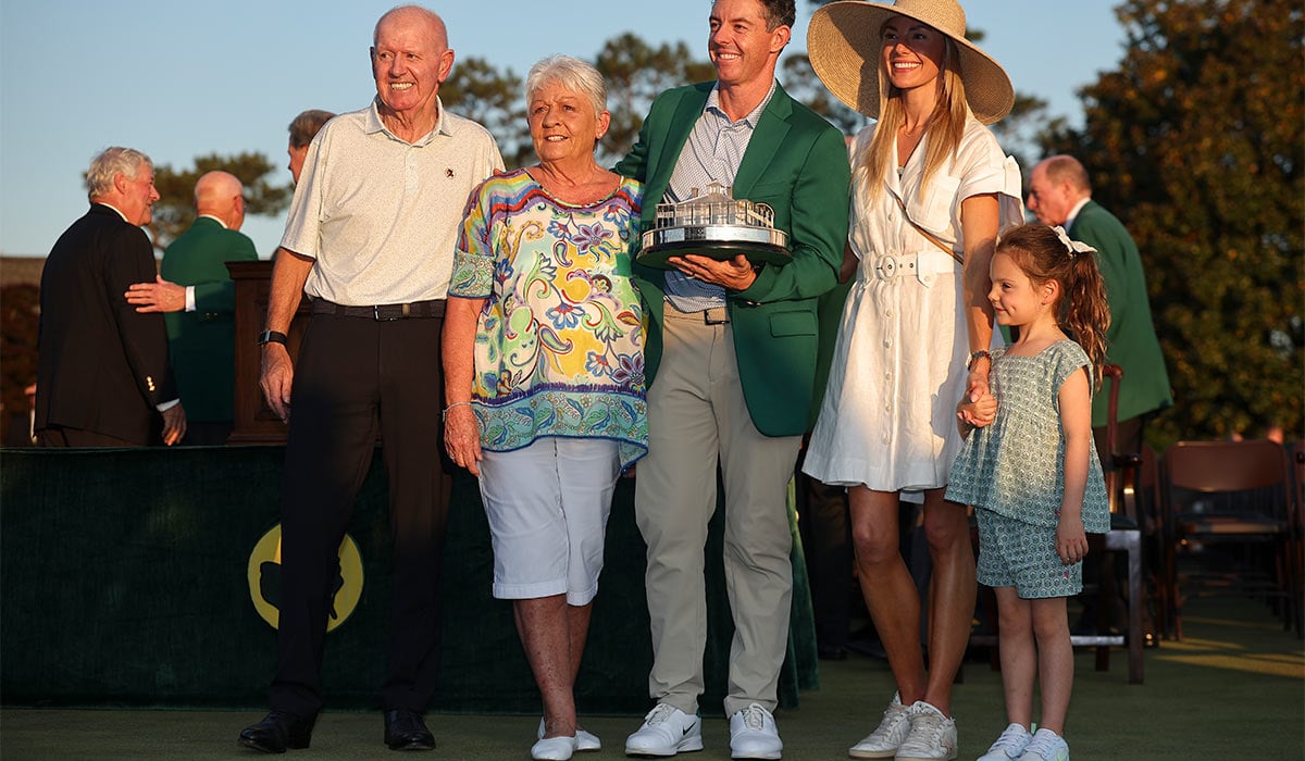 Rory McIlroy (C) of Northern Ireland poses with the Masters trophy during the Green Jacket Ceremony alongside father Gerry (L), mother Rosie (2nd L), wife Erica (2nd R) and daughter Poppy (R) after winning during the final round of the 2026 Masters Tournament at Augusta National Golf Club. Pic: Getty Images