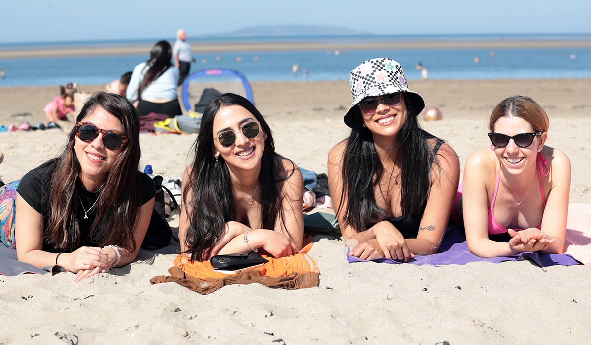 Mariana, from Mexico, Stefania and Jessica, from Chile, and Patricia, from Spain, enjoying the sunshine at Burrow Beach in Dublin. Pic: Leah Farrell/RollingNews.ie