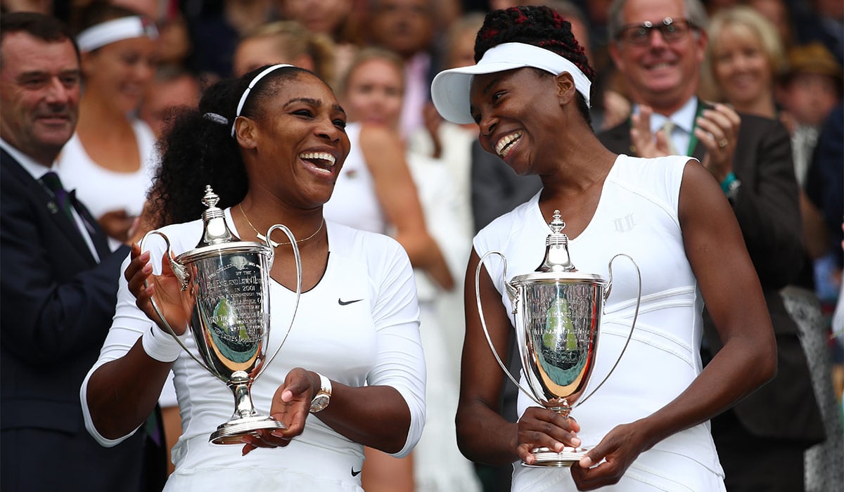Venus Williams and Serena Williams hold their trophies following victory in the Ladies Doubles Final in 2016