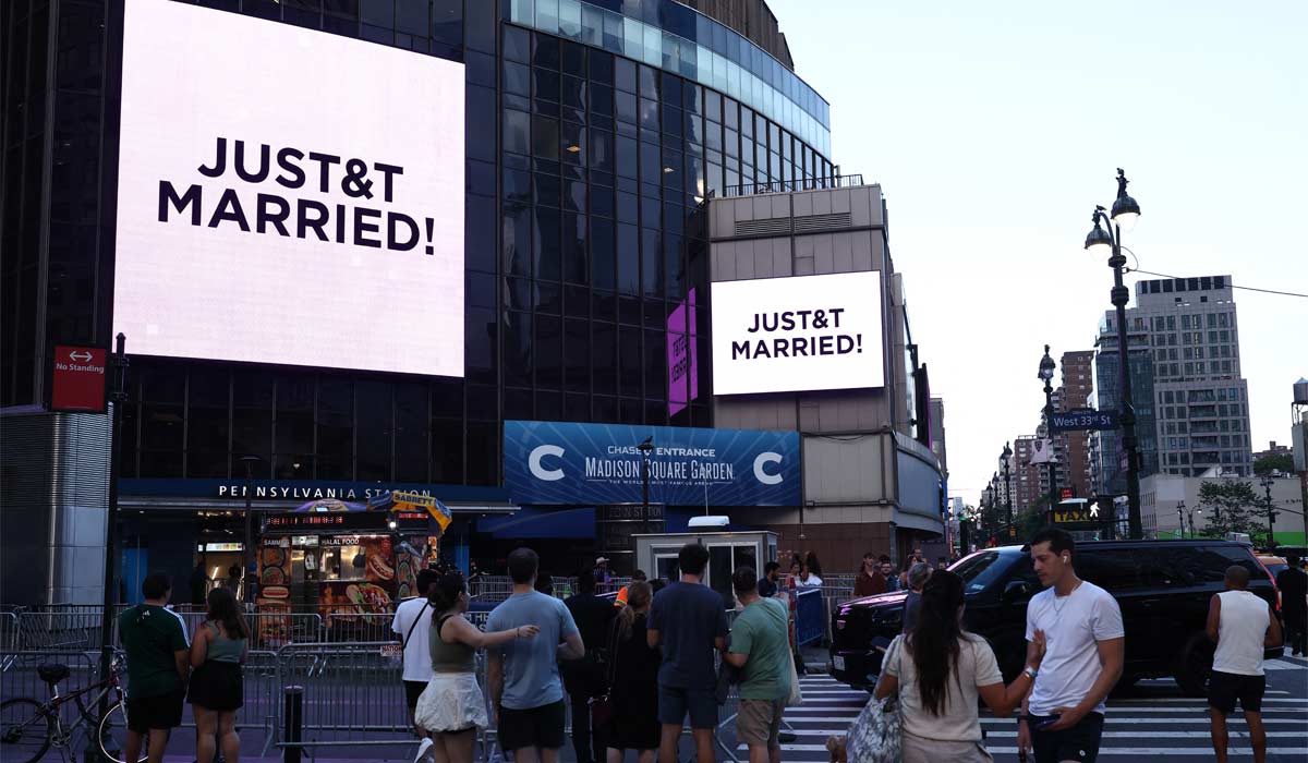 People watch giant screens showing the message "JUST&T MARRIED!" (T&T for Taylor and Travis) outside Madison Square Garden, the reported venue for the wedding celebrations of pop singer Taylor Swift and pro-athlete Travis Kelce, in New York City on July 3, 2026. US pop queen Taylor Swift and NFL star Travis Kelce, whose lavish wedding has drawn hundreds of celebrities to New York, have officially married, a representative for the singer said July 3. "Taylor and Travis did not have bridesmaids or groomsmen. Instead, her brother Austin Swift served as Taylor's Man of Honor and Jason Kelce was Travis's Best Man," Swift's longstanding publicist Tree Paine said in a statement. (Photo by CHARLY TRIBALLEAU / AFP via Getty Images)