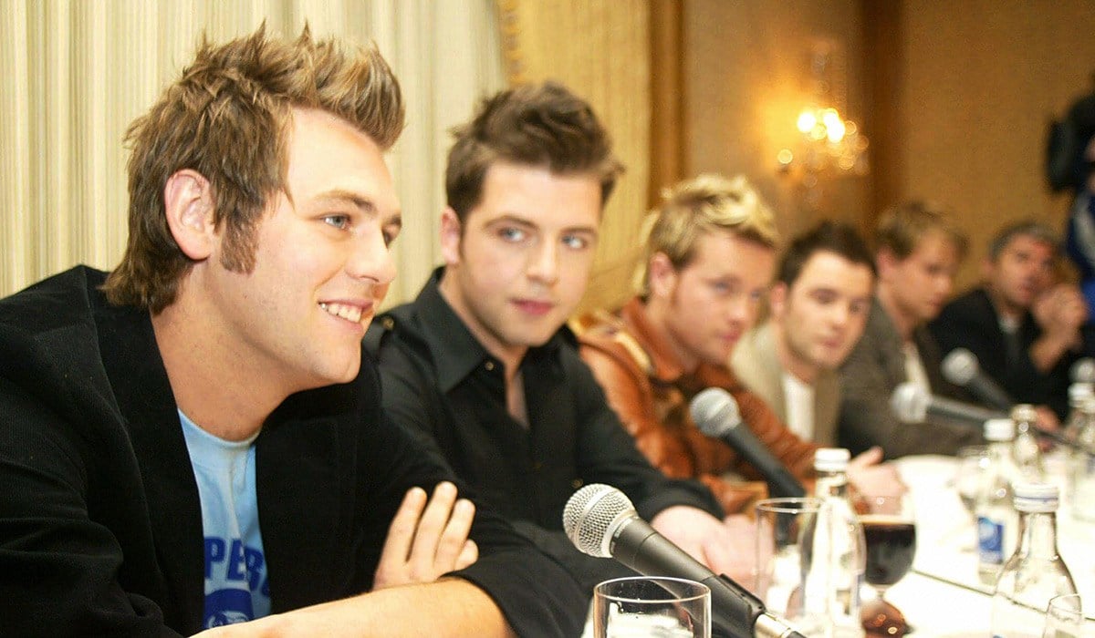 Dublin, IRELAND: Westlife band member Brian McFadden (L) sits with fellow band members (2nd L-R) Mark Feehily, Nicky Byrne, Shane Filan and Kian Egan at press conference to announce Brian McFadden departure from Westlife 08 March, 2004 in Dublin. AFP PHOTO/FRAN CAFFREY (Photo credit should read Fran Caffrey/AFP via Getty Images)