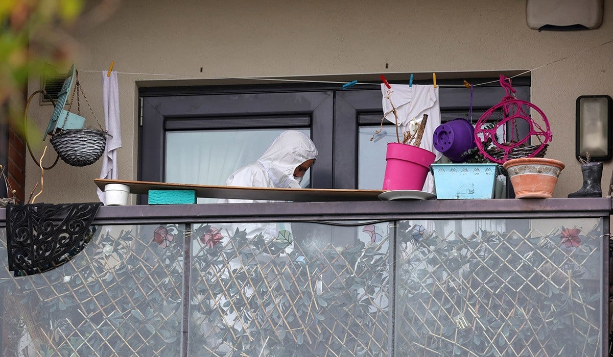 A member of the Garda Technical Bureau examines a balcony of a second story apartment pictured at the scene on Main Street, Belmayne, Dublin 13 this afternoon after an alleged serious assault on a woman in her 30's yesterday afternoon. Pic: Colin Keegan, Collins, Dublin